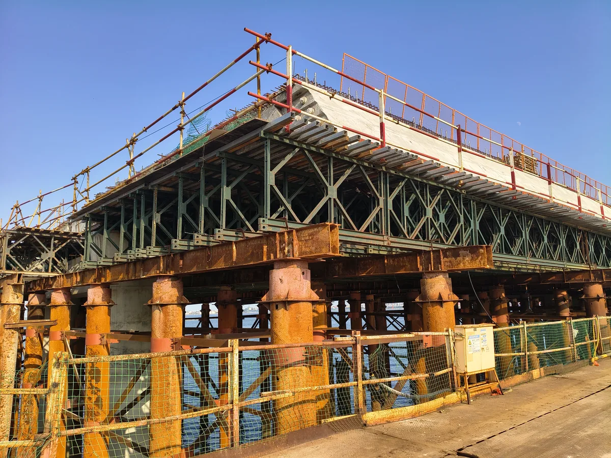 Bailey trusses and deck formwork on steel pipe pile bents along a sea crossing