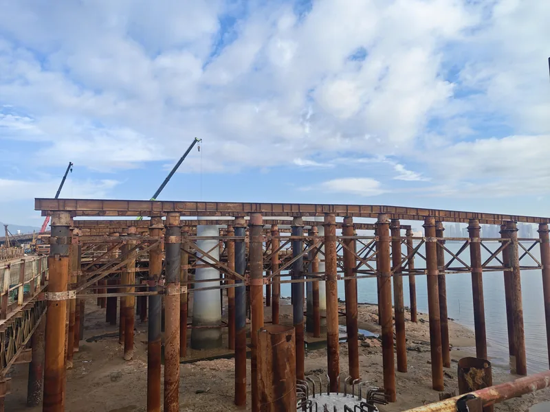 Steel pipe pile group with capping steel around a pier