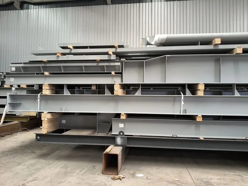 Painted plate girders stacked on timber bearers with position number 6 marked