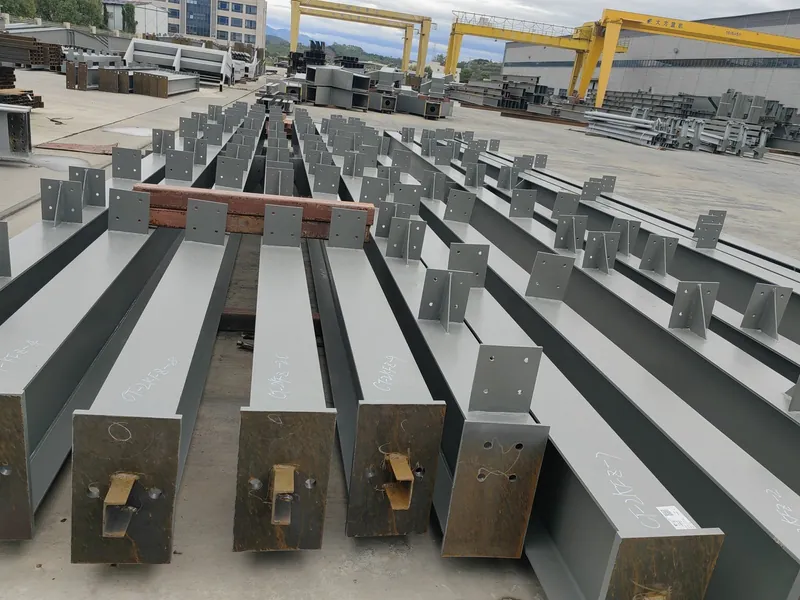 Fabricated girders in the outdoor yard with gantry cranes overhead