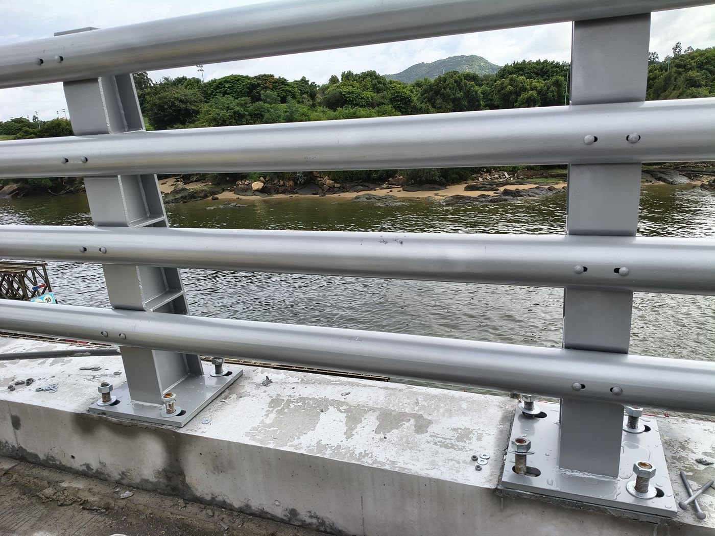 Three-tube galvanised bridge guardrail on a coastal crossing